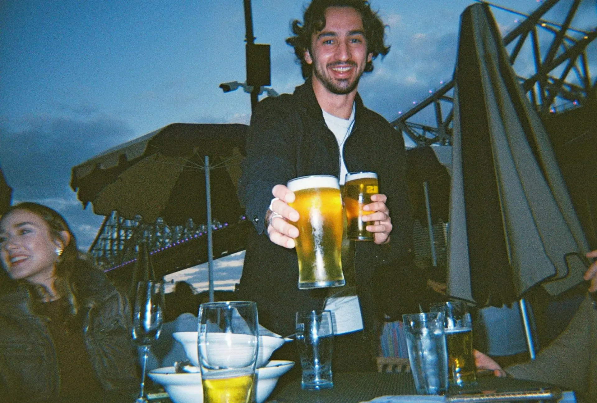 Mann gibt ein Bier her
